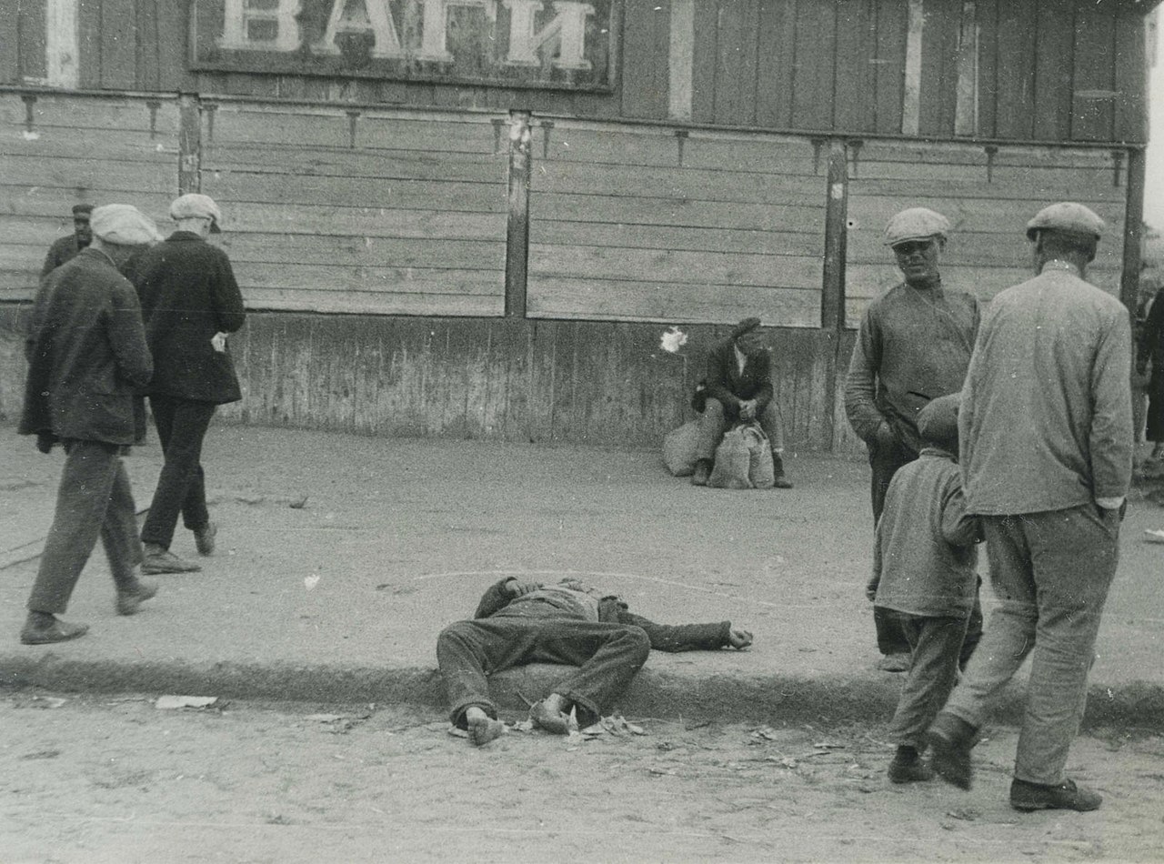 Photo: Passers-by and the corpse of a starved man on a street in Kharkiv (1932)